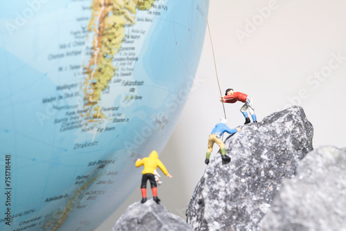 Bergsteiger klettern auf einen Globus, miniaturfiguren fotografie photo