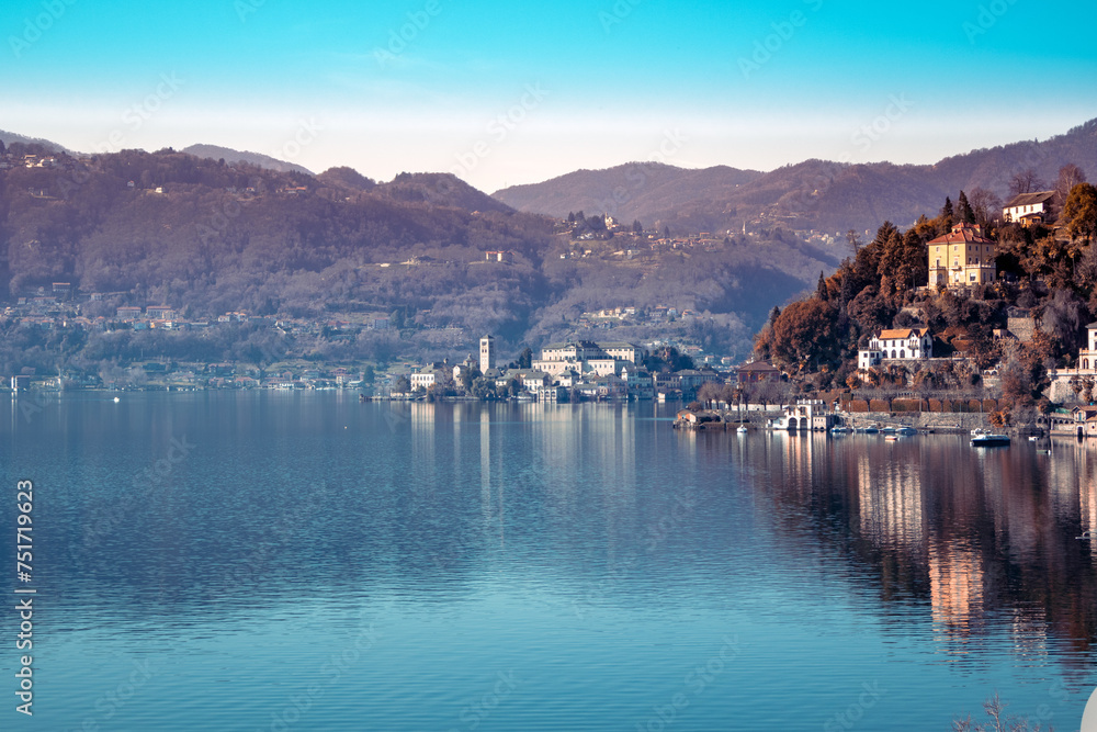 San Giulio Island in a dreamy light of winter and water reflection - Lake Orta, Italy