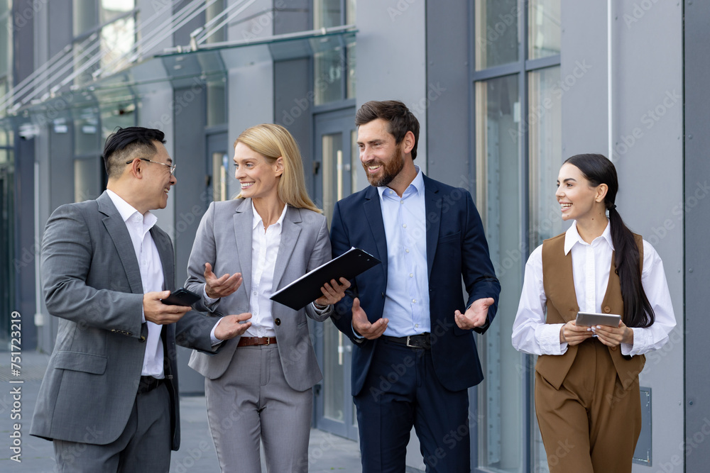 Group of happy business professionals in a casual meeting outside an office. They are discussing work and sharing a laugh. Group of happy business professionals in a casual meeting outside an office. They are discussing work and sharing a laugh.