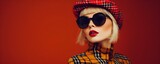 Fashionable portrait of a young woman in a beret cap plaid jacket and retro sunglasses. Concept Fashion Photography, Vintage Style, Beret Hat, Plaid Jacket, Retro Sunglasses