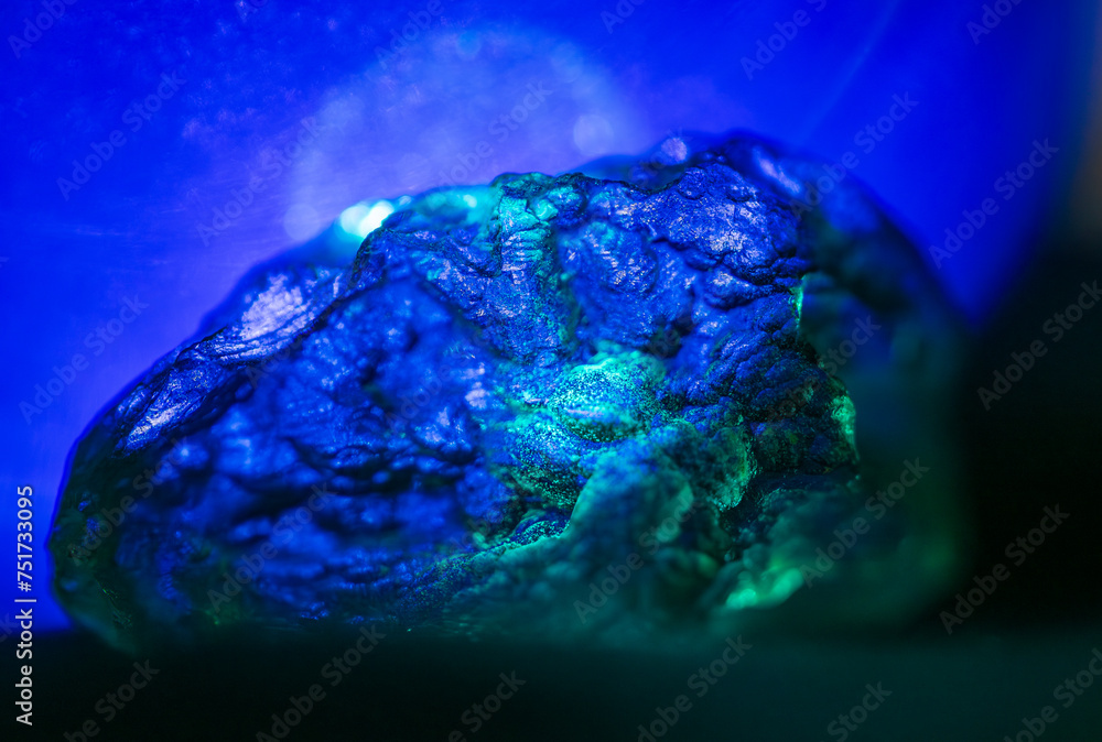 Close up texture detail on Moldavite rock in blue light Close up texture detail on Moldavite rock in blue light