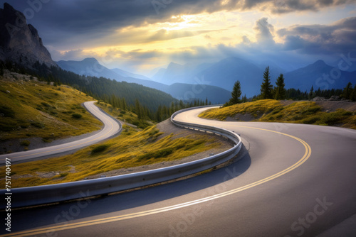 Winding mountain road with sun shining through clouds in the sky. High quality photo