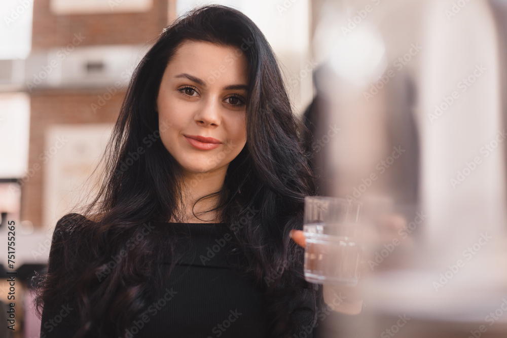 Delighted girl sitting in the cafe hold and drink glass of water. Food, leisure and people concept. Brunette hair woman wear black long sleeves top. Delighted girl sitting in the cafe hold and drink glass of water. Food, leisure and people concept. Brunette hair woman wear black long sleeves top.