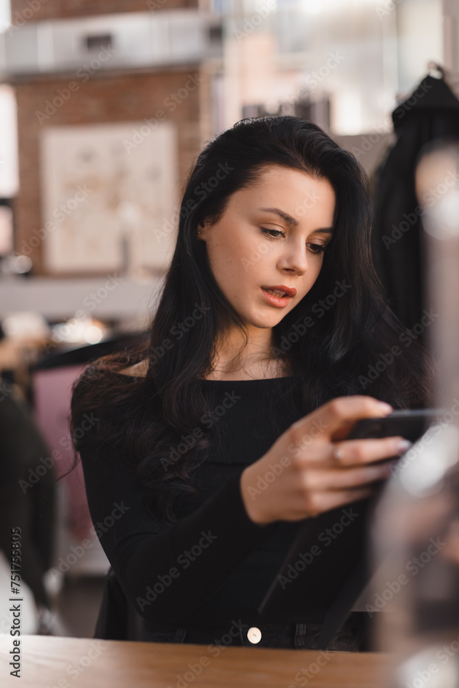 Attractive brunette woman sitting with tablet computer in cafe. Teen girl student using tablet computer for social media, studying or reading news. Attractive brunette woman sitting with tablet computer in cafe. Teen girl student using tablet computer for social media, studying or reading news.