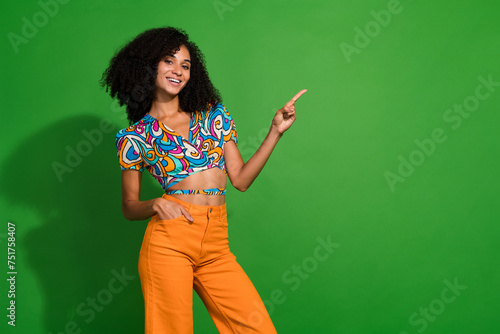 Photo of nice smiling young charming girlfriend wearing exotica style outfit point finger empty space isolated over green color background