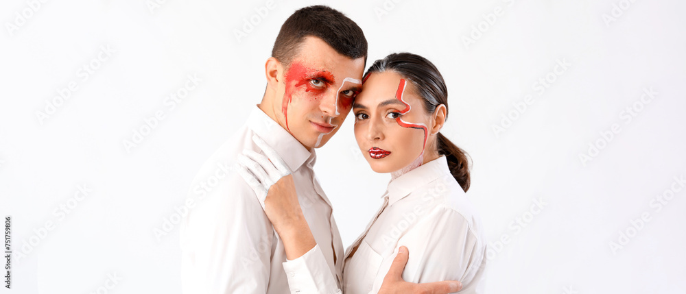 Young couple with painted faces hugging on white background Young couple with painted faces hugging on white background