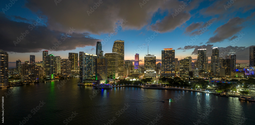 Obraz premium View from above of brightly illuminated high skyscraper buildings in downtown district of Miami Brickell in Florida, USA. American megapolis with business financial district at night