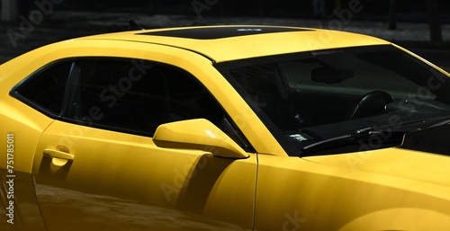 Rearview mirror and front pillar of a beautiful yellow car with black-tinted windows