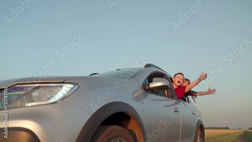 boy girl car window cheerfully waving hands, happy children journey, wind child hair, dream flying, car carries kid sister brother family trip, happy family, kindergarten, family trip car vacation,