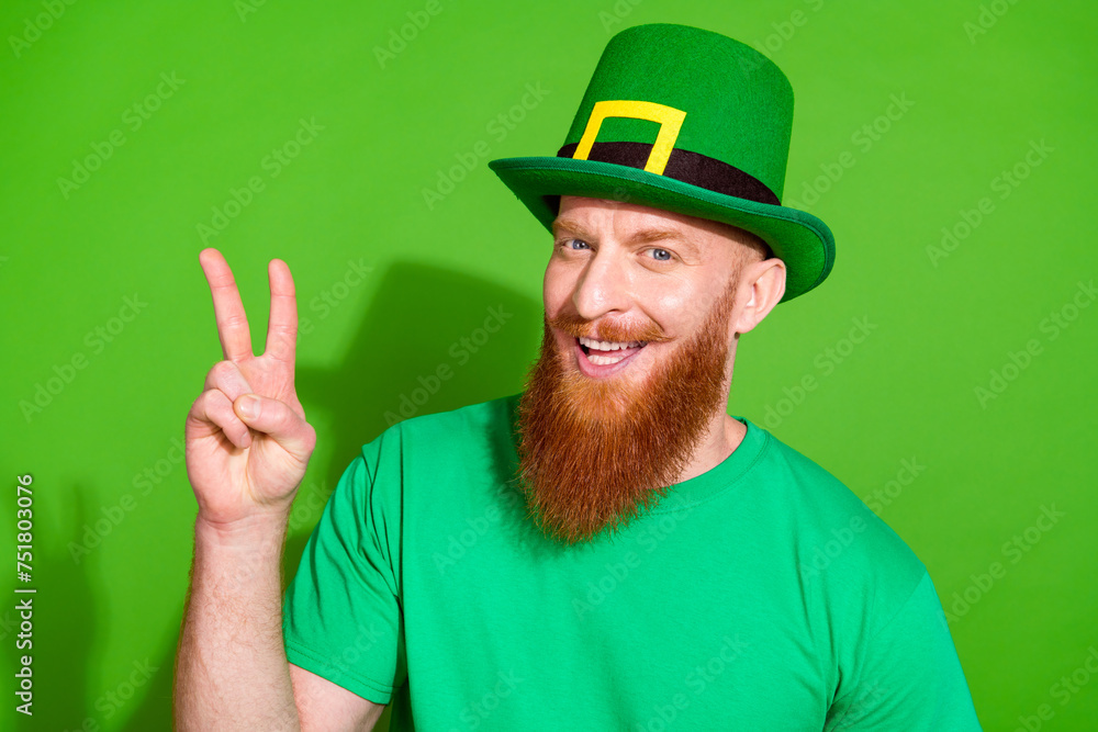 Photo of nice positive person toothy smile hand fingers demonstrate hello greeting v-sign isolated on green color background Photo of nice positive person toothy smile hand fingers demonstrate hello greeting v-sign isolated on green color background