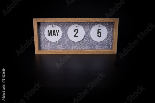 A wooden calendar block showing the date May 26th on a dark black background, save the date or date of an event concept.