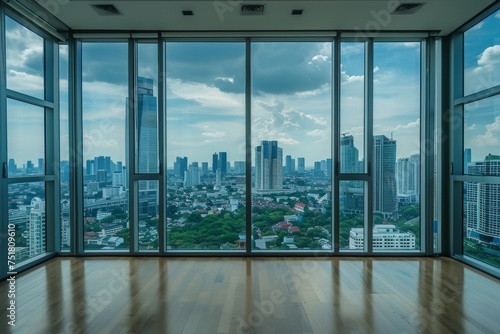 A bare expansive interior space opens to a sweeping cityscape through clear glass windows