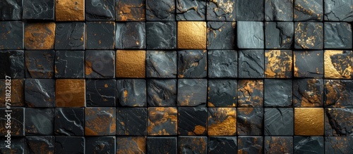 A wall composed of black and gold tiles, accented with shiny gold squares in a stylish pattern.