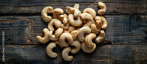 A pile of cashews neatly stacked on a wooden table, showcasing the rich texture and earthy colors of the nuts.