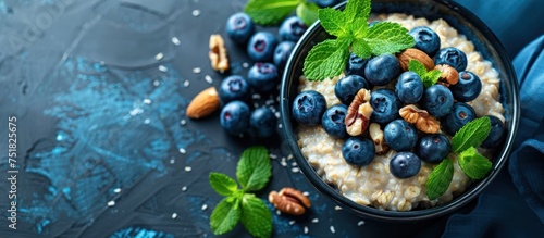 A bowl filled with oatmeal topped with fresh blueberries and walnuts, sitting on a rustic background.