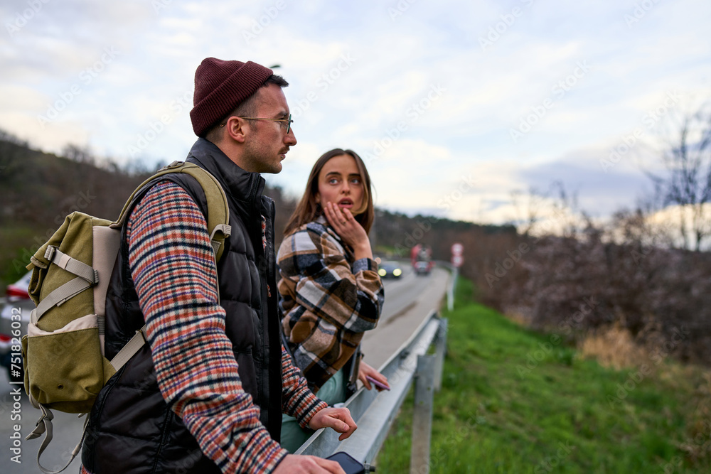 Travelers with backpacks reacting to a view by the highway