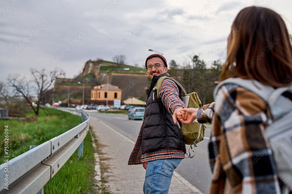 Obraz premium Adventurous travelers sharing a playful walk on the road