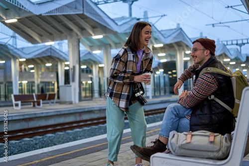 In the comfort of each others company, a couple engages in a playful conversation while waiting for their train, their connection evident.