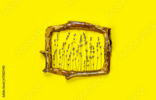 Wooden frames with  bouquet of fragrant lavender in  rustic style on yellow wall. Holiday party decoration.