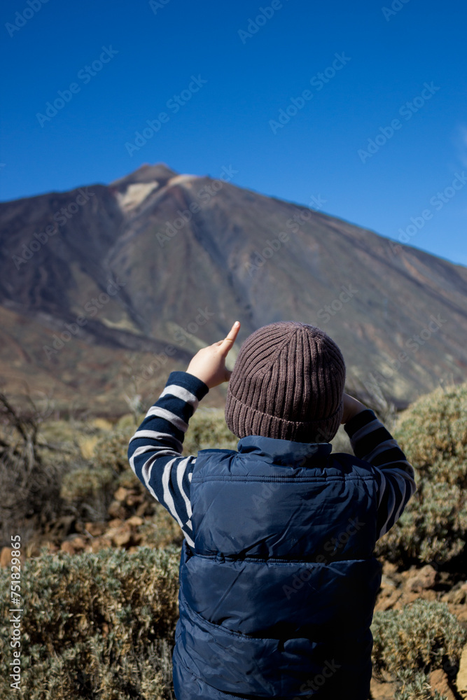 Young traveler. Boy of 4 years old looks at volcano Teide in front of him.