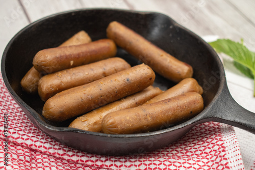 vegan mini sausages in cast iron pan