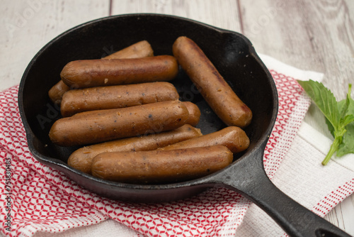 vegan mini sausages in cast iron pan