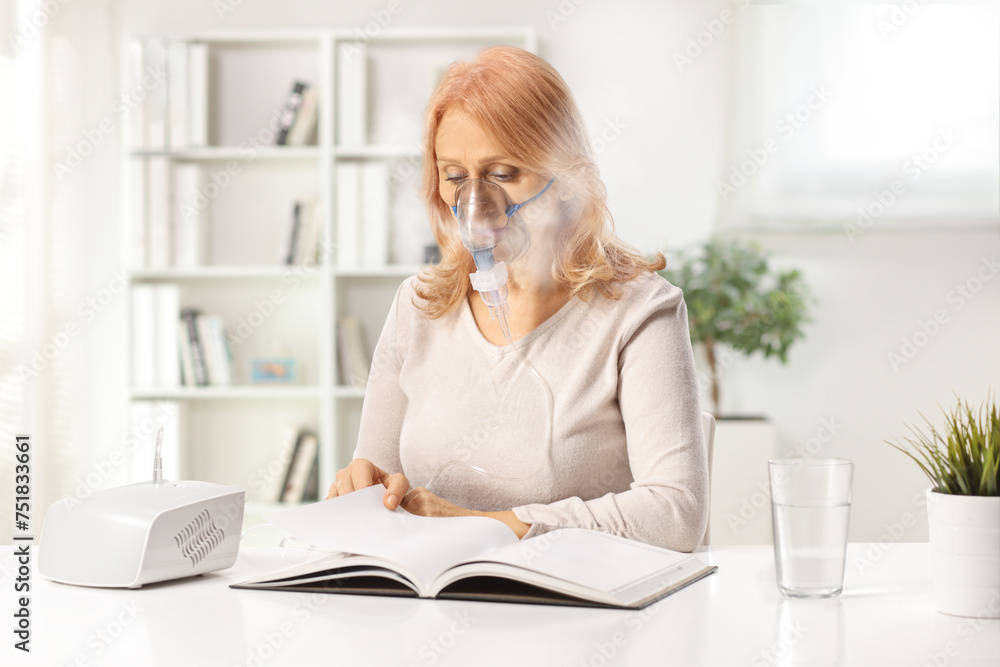 Woman reading a book and using a nebulizer at home Woman reading a book and using a nebulizer at home