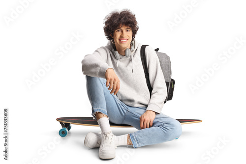 Happy young man sitting on a skateboard