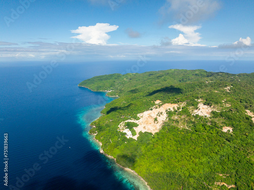 Blue sea in Romblon Island with green plants. Blue sky and clouds. Philippines.