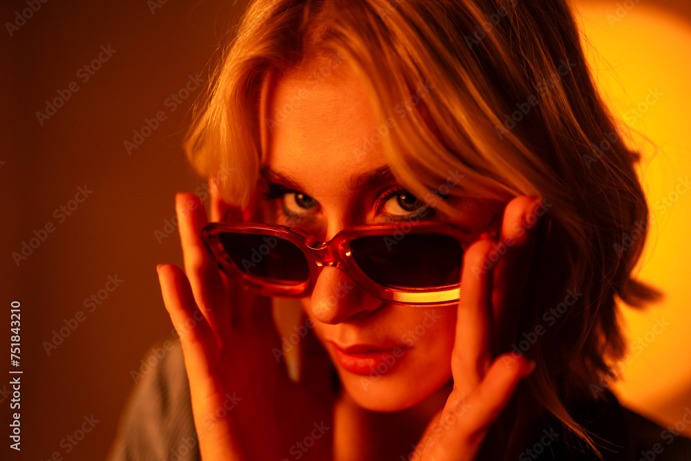 A woman wearing sunglasses is covering her face with her hands A woman wearing sunglasses is covering her face with her hands