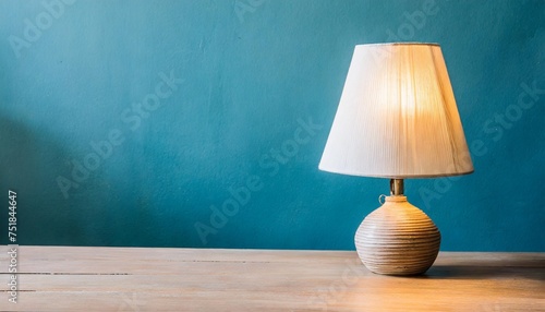 lampshade lamp on table on blue wall background photo