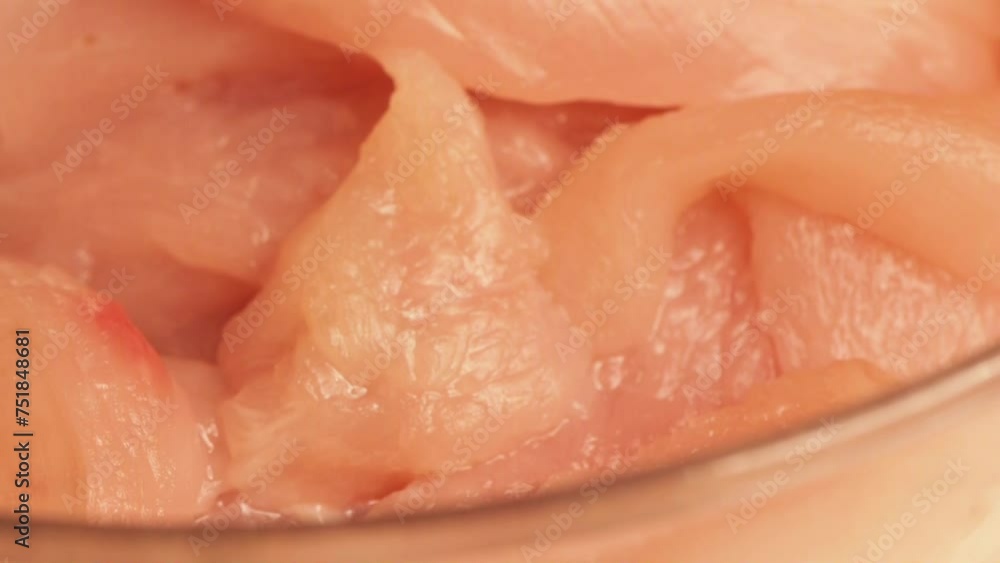 Raw chicken fillet in glass bowl rotates on table. Raw chicken fillet in glass bowl rotates on table.
