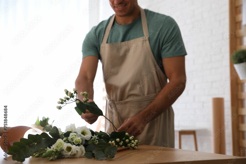 Florist making beautiful bouquet at table in workshop, closeup Florist making beautiful bouquet at table in workshop, closeup