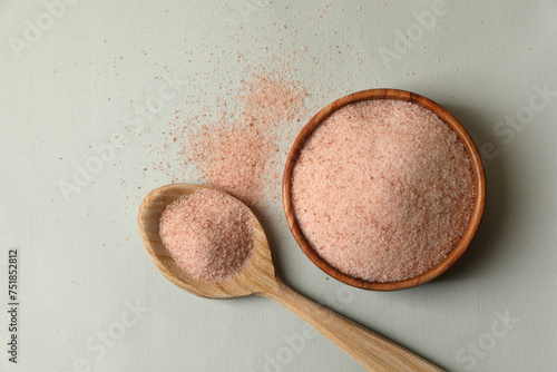 Himalayan salt in bowl and spoon on grey background, flat lay