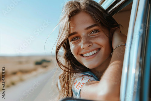 portrait of a cute smiling woman leaning out of the car window at a sunny day