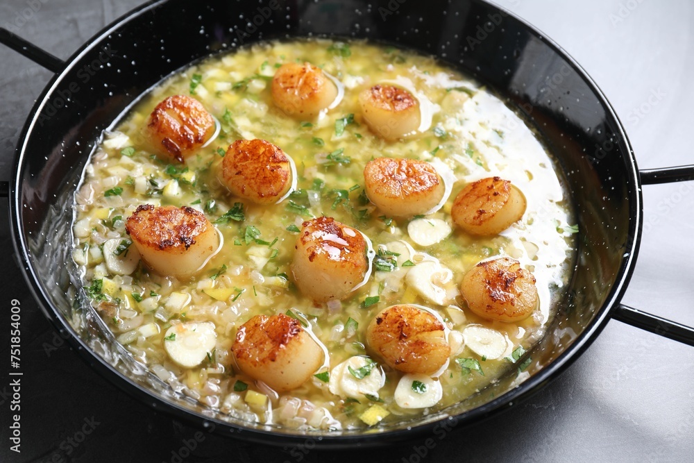Fried scallops with sauce in dish on grey table, closeup Fried scallops with sauce in dish on grey table, closeup