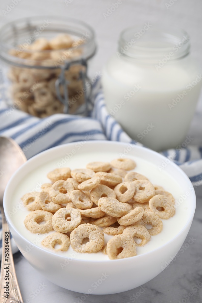 Breakfast cereal. Tasty corn rings with milk in bowl on white marble table Breakfast cereal. Tasty corn rings with milk in bowl on white marble table
