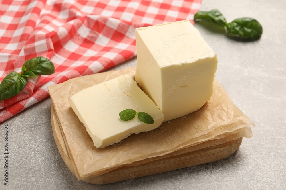 Block of tasty butter with basil on grey table Block of tasty butter with basil on grey table