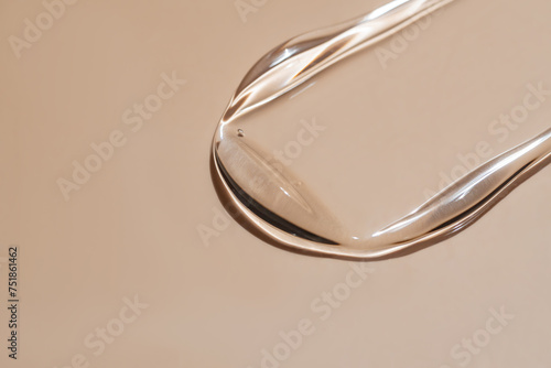 Close-up of liquid serum swatch on beige background