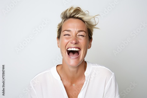 Portrait of a happy woman screaming with closed eyes against white background © Igor