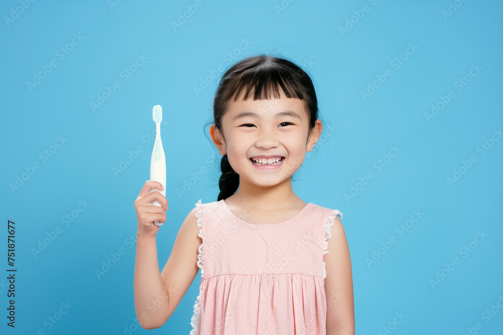 Chinese girl with toothbrush in her hand, on light blue background Chinese girl with toothbrush in her hand, on light blue background