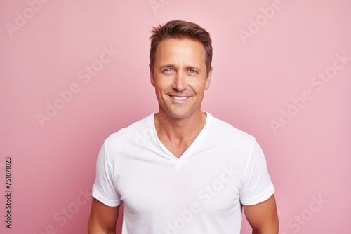 Portrait of handsome young man in white t-shirt on pink background