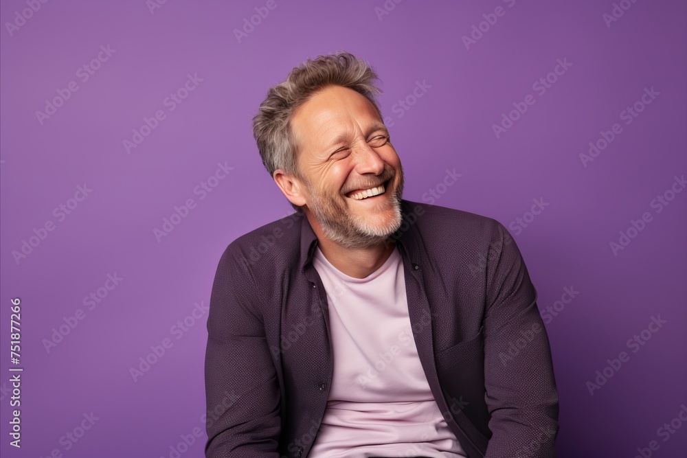 Portrait of a happy senior man laughing while standing against purple background Portrait of a happy senior man laughing while standing against purple background