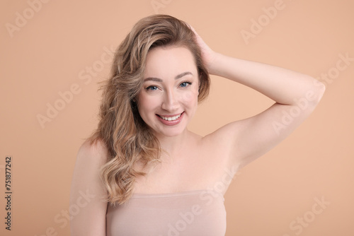 Portrait of smiling woman on beige background