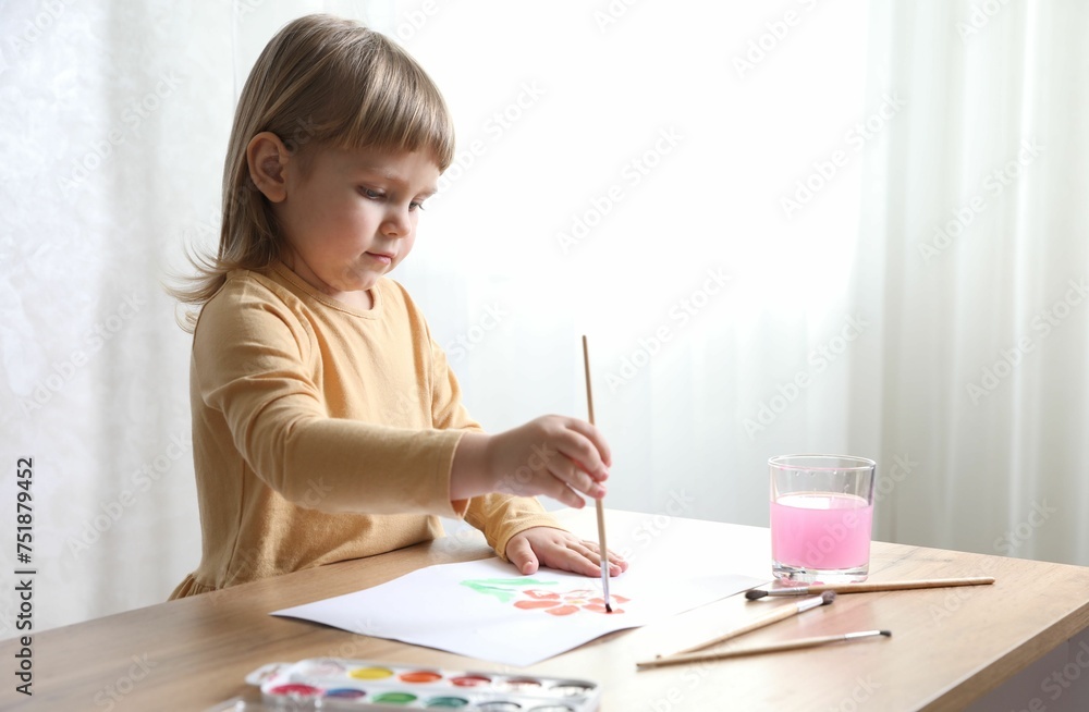 Cute little girl drawing with brush at wooden table indoors. Child`s art Cute little girl drawing with brush at wooden table indoors. Child`s art