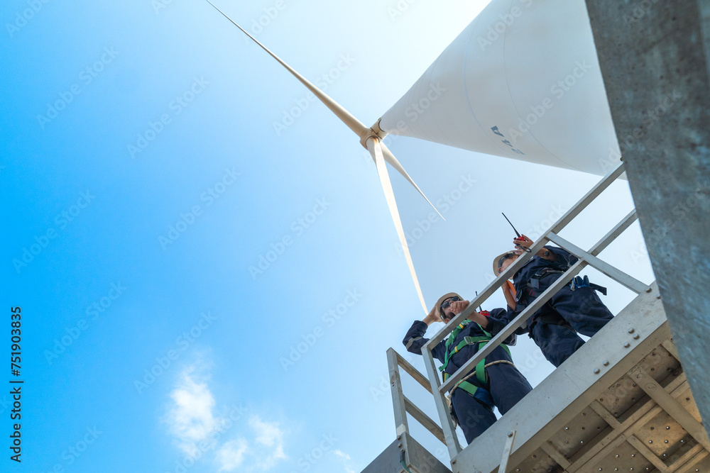 engineers working in fieldwork outdoors. Workers check and inspect construction and machine around the building project site. Wind turbines for electrical clean energy and environment sustainability.