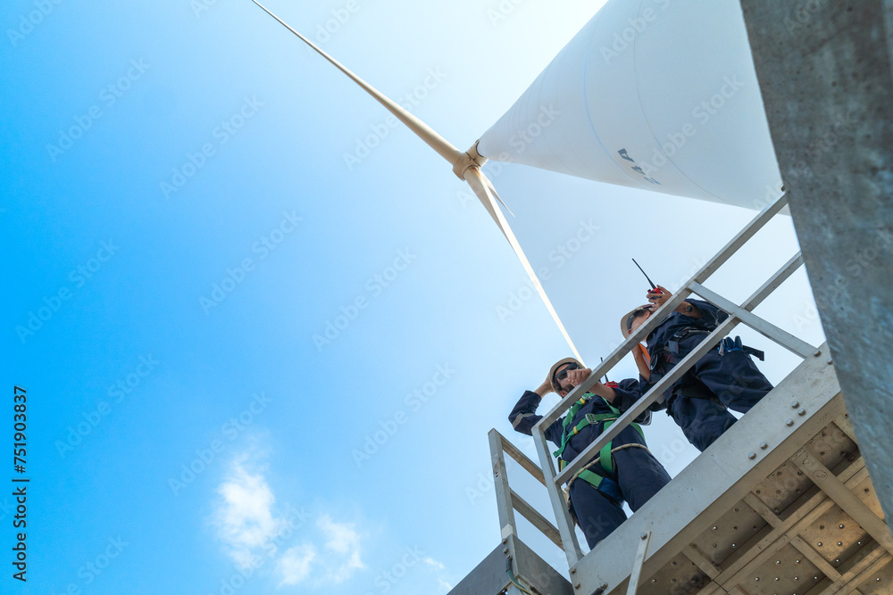 engineers working in fieldwork outdoors. Workers check and inspect construction and machine around the building project site. Wind turbines for electrical clean energy and environment sustainability.