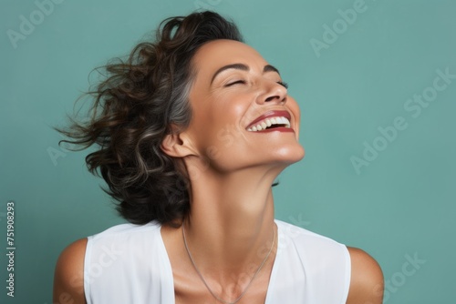 Portrait of beautiful laughing woman with closed eyes and wavy hair.