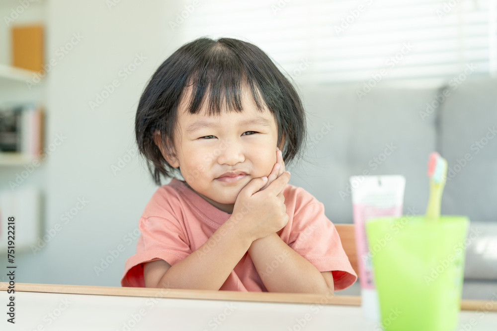 little asian girl presses hand to cheek, suffers from pain in tooth. Teeth decay, dental problems, child emotions and facial expression, oral health care, reducing sweets, fluorine coating. little asian girl presses hand to cheek, suffers from pain in tooth. Teeth decay, dental problems, child emotions and facial expression, oral health care, reducing sweets, fluorine coating.