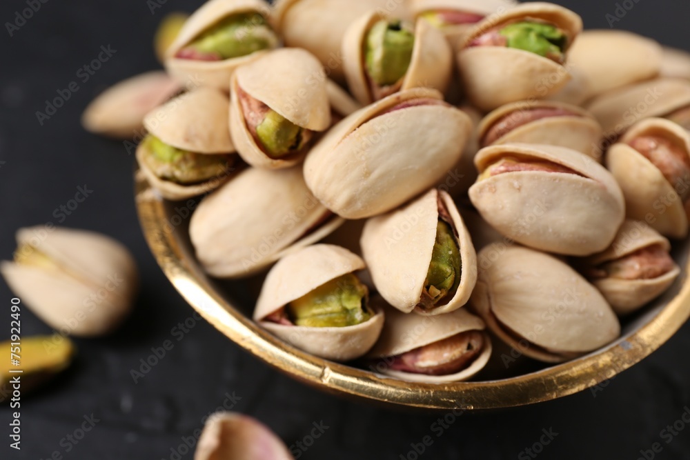 Tasty pistachios in bowl on black table, closeup Tasty pistachios in bowl on black table, closeup